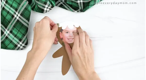 hand gluing icing hair photo to gingerbread man craft