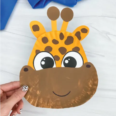 hand holding brown and yellow paper plate giraffe craft