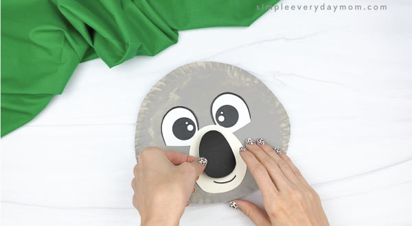 hand gluing nose to paper plate koala