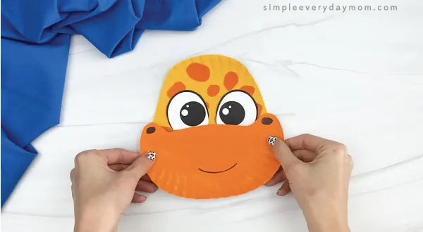 hands gluing mouth to paper plate giraffe