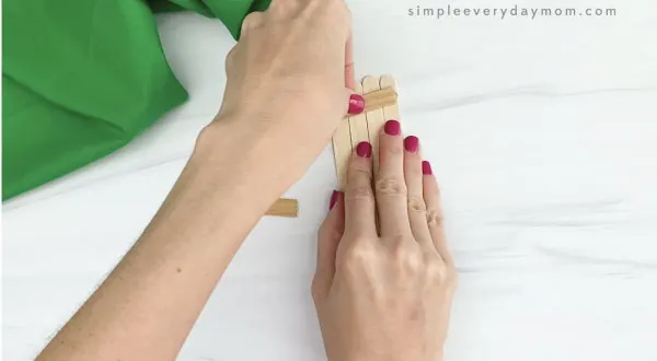 hand gluing popsicle sticks together