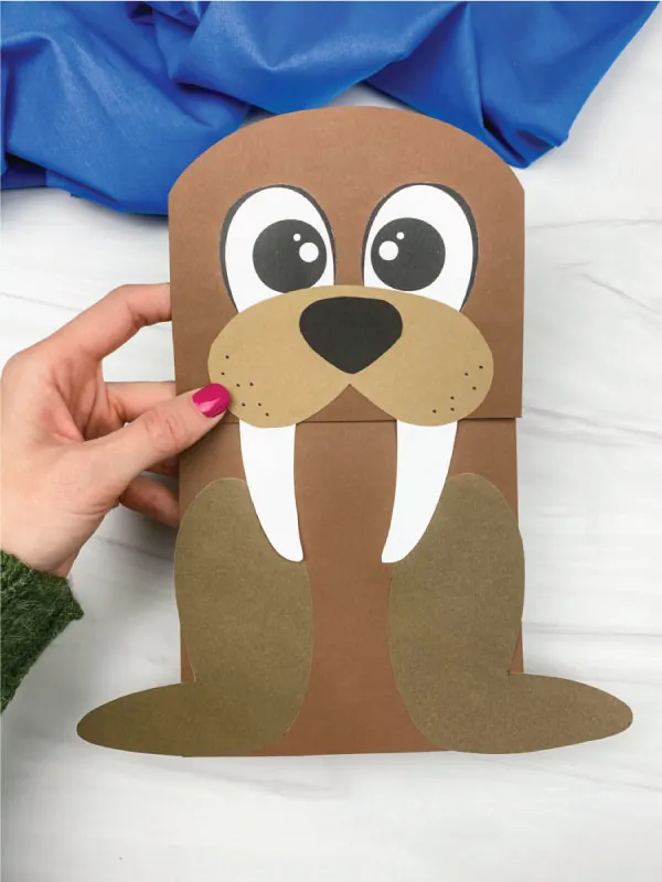 hand holding walrus paper bag craft