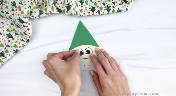 hands gluing eyes onto paper elf craft