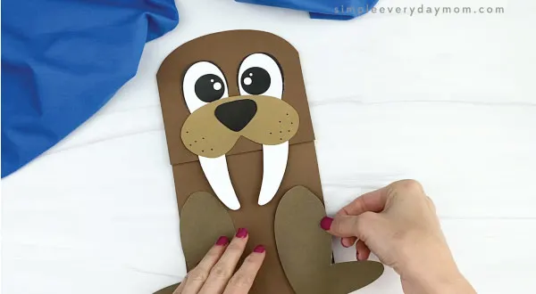 hand gluing flippers to paper bag walrus craft