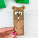 hand holding popsicle stick groundhog craft