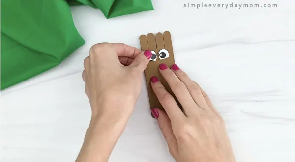 hand gluing eyes to popsicle stick groundhog craft