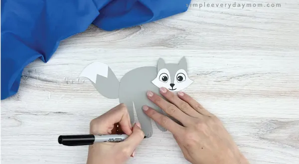 hand drawing paws onto handprint arctic fox