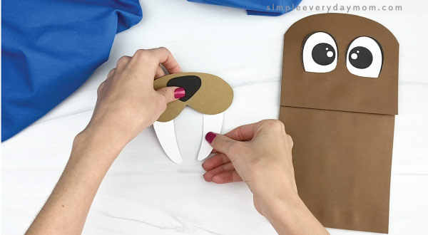 hand gluing tusks to paper bag walrus mouth