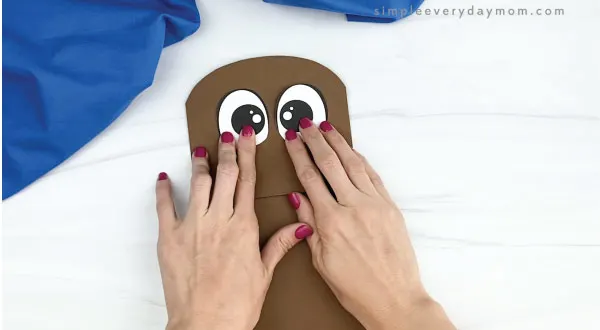 hand gluing eyes to paper bag walrus craft
