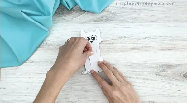 hands gluing inner legs to popsicle stick arctic fox