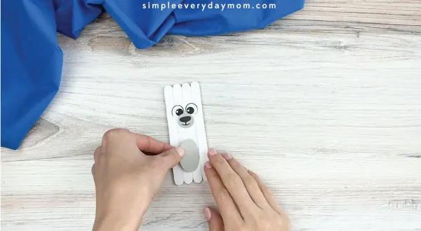 hands gluing belly onto popsicle stick polar bear craft