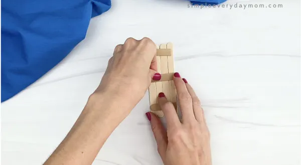 hand gluing popsicle sticks together
