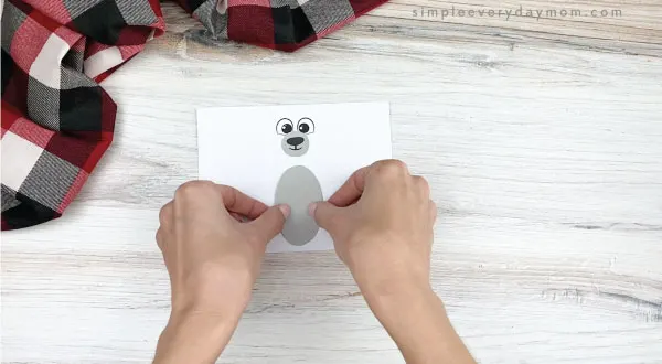 hands gluing belly to toilet paper roll polar bear craft