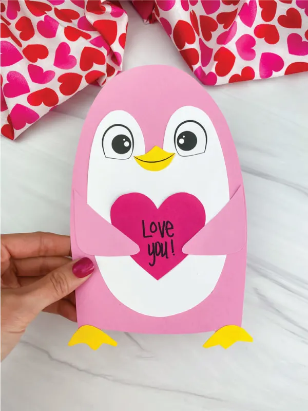 hand holding penguin valentine craft