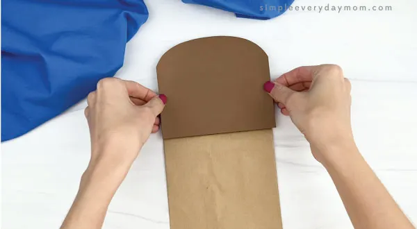 hand gluing head to paper bag walrus craft