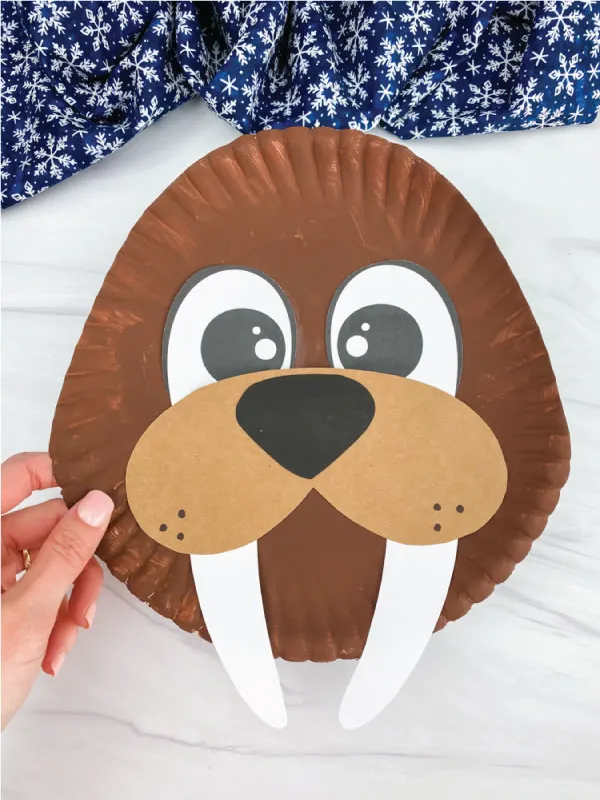 hand holding paper plate walrus craft