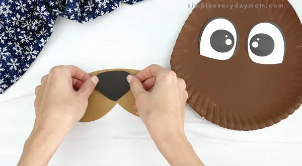 hand gluing nose to paper plate walrus craft