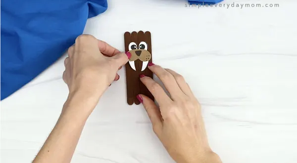 hand gluing nose and mouth to popsicle stick walrus craft