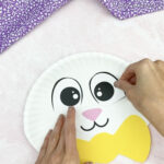 hand gluing eyes to paper plate Easter bunny craft