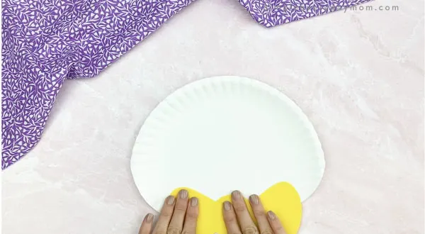 hand gluing bowtie to paper plate Easter bunny craft