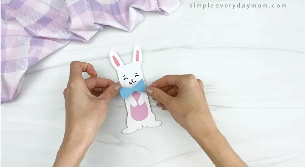 hand gluing bowtie to popsicle stick easter bunny craft