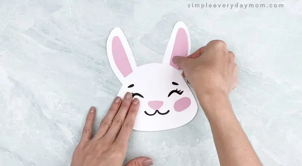 hands gluing inner ears to Easter bunny headband craft