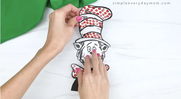 hand gluing hat to cat in the hat craft