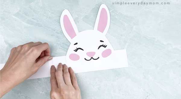 hands taping headband extender to base of bunny headband