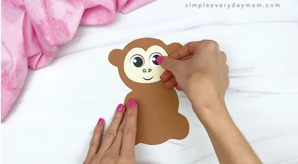 hand gluing eyes to monkey valentine craft