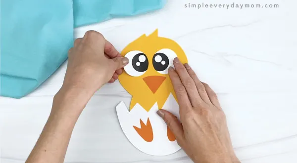 hand gluing eyes onto hatching chick craft