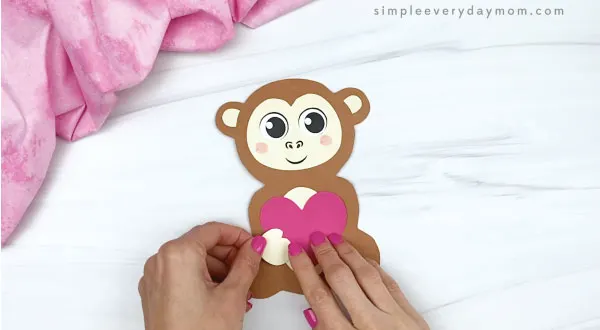 hand gluing hands to monkey valentine craft