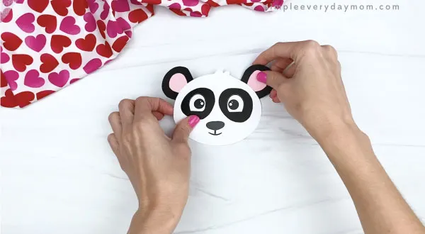 hand gluing ears to panda valentine craft