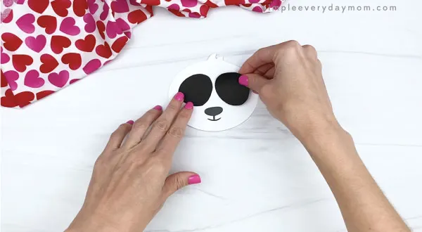 hand gluing black eye spots to panda valentine craft