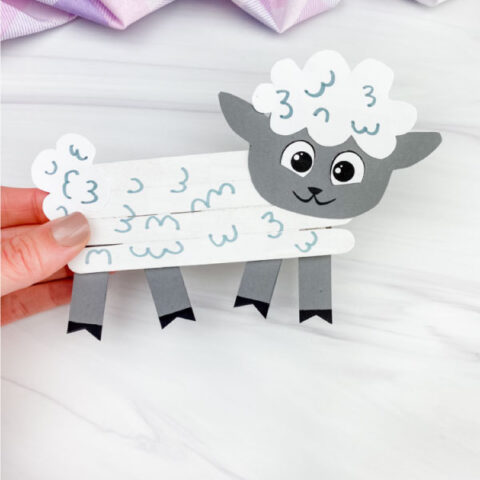 hand holding popsicle stick sheep craft
