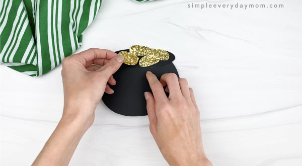 hand gluing coins to pot of gold card craft