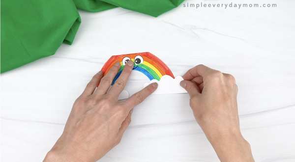 hand gluing clouds to rainbow card craft