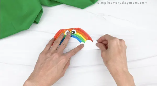 hand gluing clouds to rainbow card craft