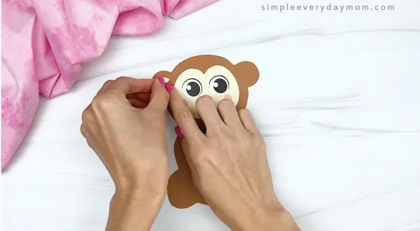 hand gluing inner ear to monkey valentine craft