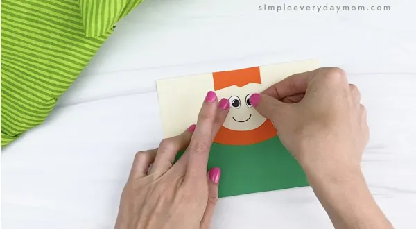 hand gluing eyes to toilet paper roll leprechaun craft