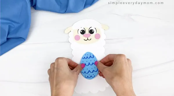 hand gluing egg to Easter sheep craft