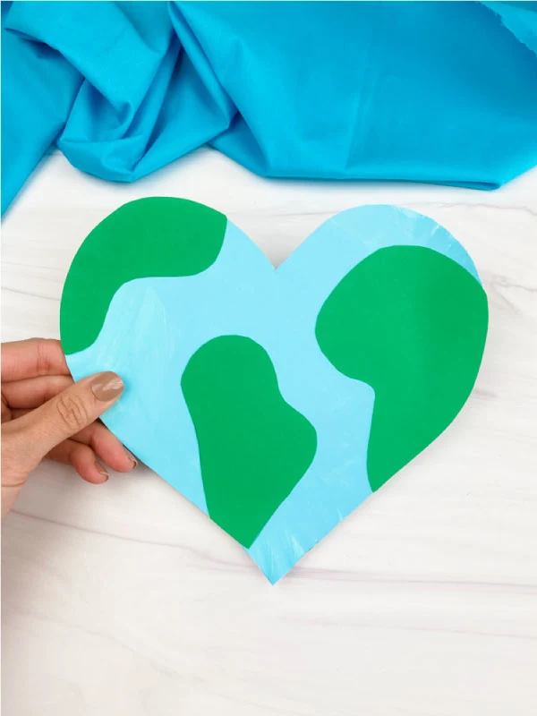 hand holding heart shaped paper plate Earth craft
