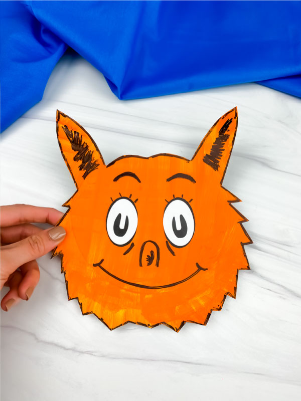 hand holding paper plate fox in socks craft