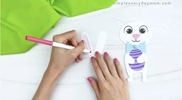 hands drawing inner ears onto paper Easter bunny craft