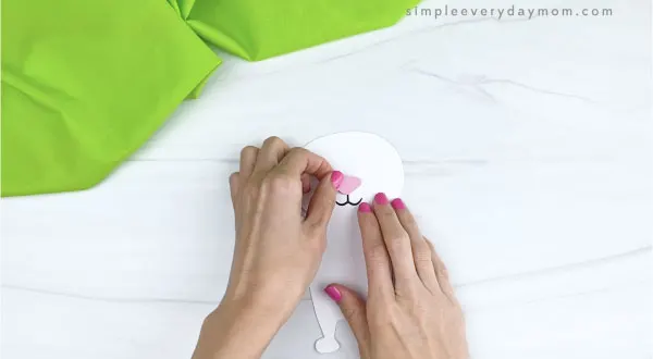 hands gluing nose onto paper Easter bunny craft
