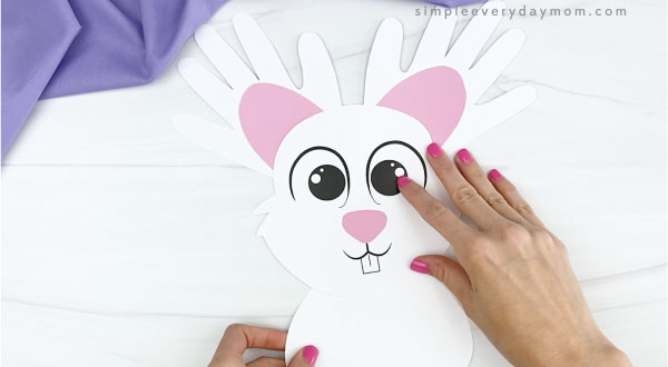 hand gluing body to handprint easter bunny craft
