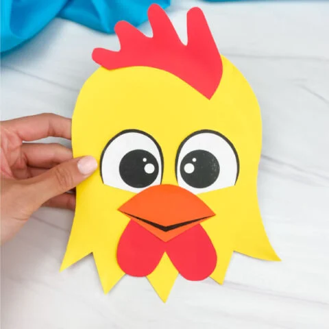 hand holding paper plate rooster craft