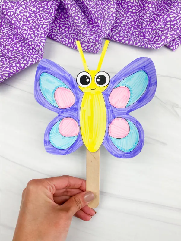 hand holding butterfly stick puppet
