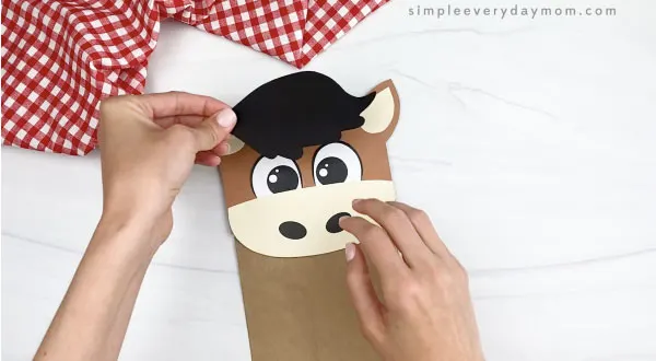 hand gluing hair to paper bag horse craft