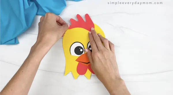 hand gluing comb onto paper plate rooster