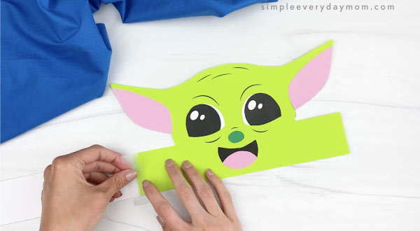 hands taping extender to Baby Yoda craft